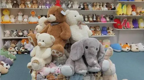 Variety of stuffed animals including bears and elephants arranged in a store showroom