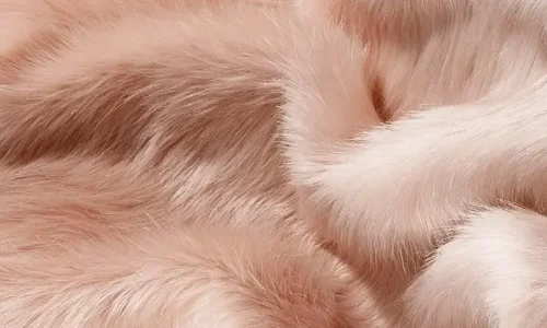 Close-Up of Soft Pink Faux Fur Fabric A detailed close-up of luxurious, soft pink faux fur fabric with a silky texture and natural-looking wave patterns.