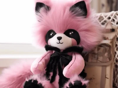 Fluffy pink panda plush toy with black accents and big eyes